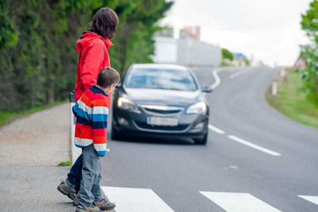 Mutter und Kind überqueren Straße | Credit: iStock.com/tepic
