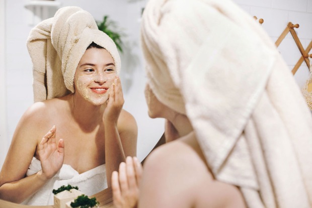 Frau reibt Peeling ins Gesicht | Credit: iStock.com/Bogdan Kurylo