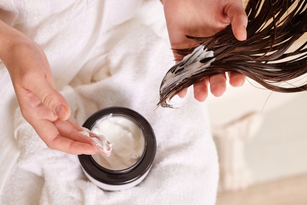 Frau pflegt ihre Haarspitzen | Credit: iStock.com/Sergii Kolesnikov