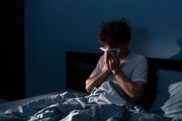 Mann niest im Bett | Credit: iStock.com/Andrii Lysenko
