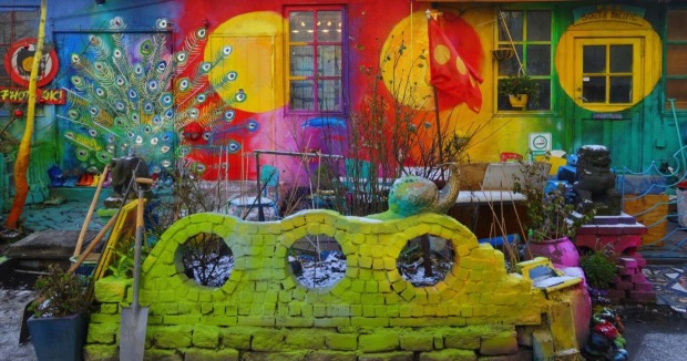 Farbenfrohe Hausfassade mit Wandmalerei und skurrilen Objekten im alternativen Viertel Christiania in Kopenhagen, einem Zentrum für Kunst und Subkultur.