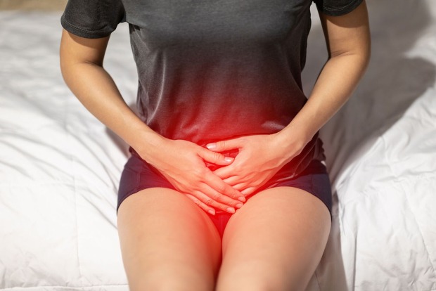 Frau hält Hände über ihren Unterbauch | Credit: iStock.com/Jomkwan