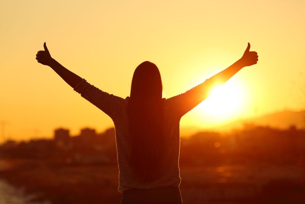 Frau steht im Sonnenaufgang | Credit: iStock.com/AntonioGuillem