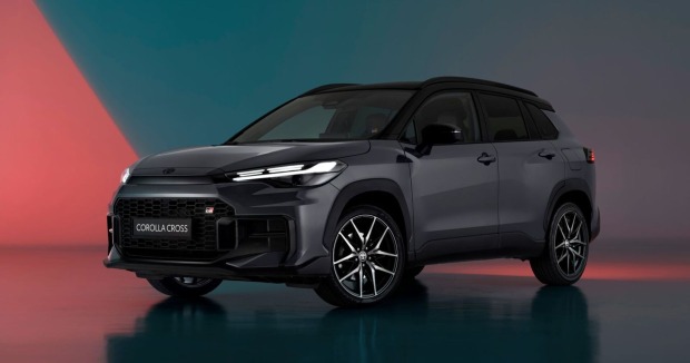 Ein schwarzer Toyota Corolla Cross parkt in einem Schauraum. Der Raum erstrahlt in blauen und roten Farbtönen.
