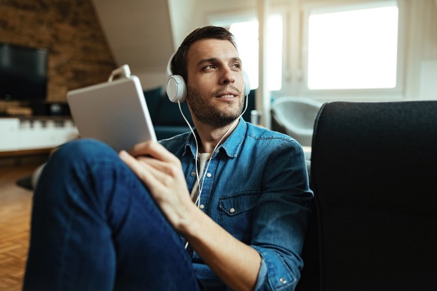 Mann hört einen Podcast | Credit: iStock.com/Drazen Zigic