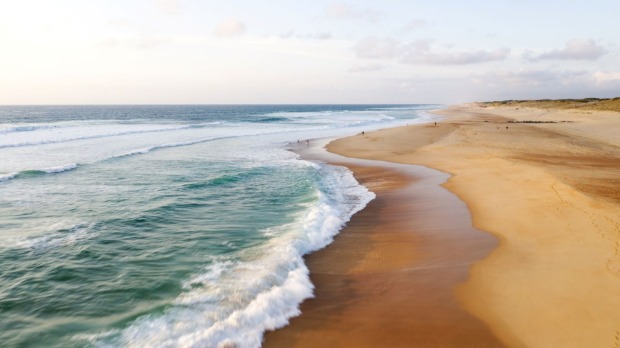 Ein weiter Strand mit goldenem Sand.