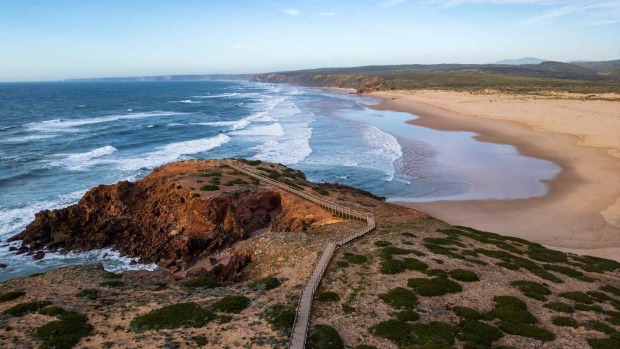 Weite Küstenlandschaft bei Carrapateira in Portugal mit Klippen, Atlantikwellen und langem Sandstrand.