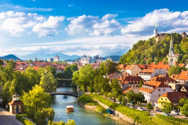 Blick über Ljubljana mit Fluss, Brücken, Altstadt und Burg auf einem Hügel