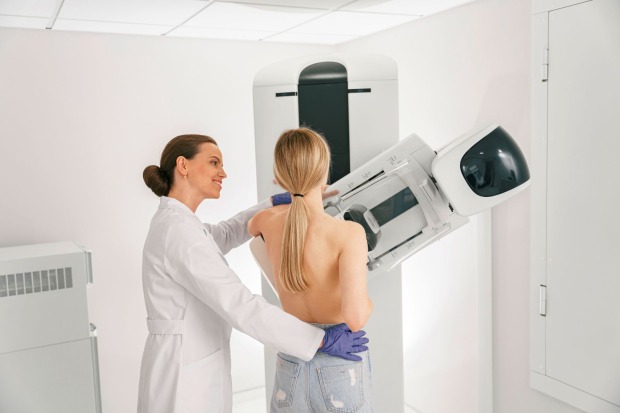 Frau bei einer Mammografie-Untersuchung mit medizinischem Fachpersonal