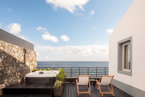 Infinity-Pool mit Liegen und Blick auf das Meer in moderner Hotelanlage
