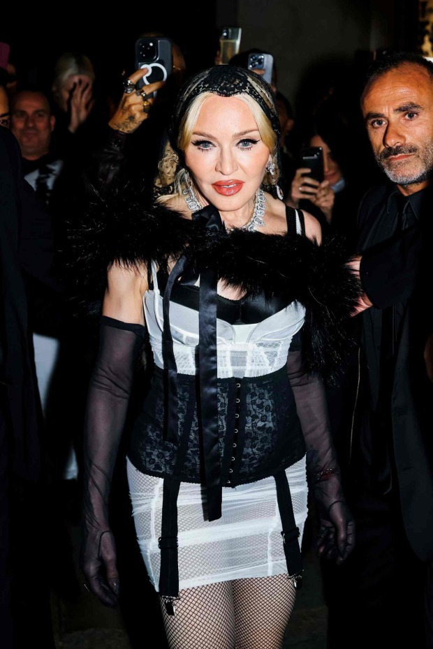Madonna in einem schwarz-weißen Corsagen-Look mit Netzstrümpfen und auffälligem Schmuck bei einem Event.