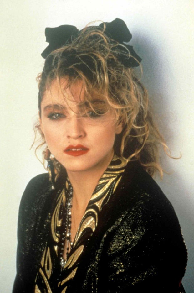 Junge Madonna mit lockigen Haaren, auffälligem Make-up und schwarzem Glitzer-Outfit in den 1980er-Jahren.