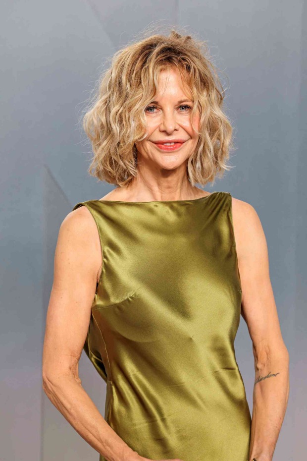 Meg Ryan mit schulterlangen blonden Wellen und olivgrünem Satinkleid bei einem aktuellen Red-Carpet-Auftritt.