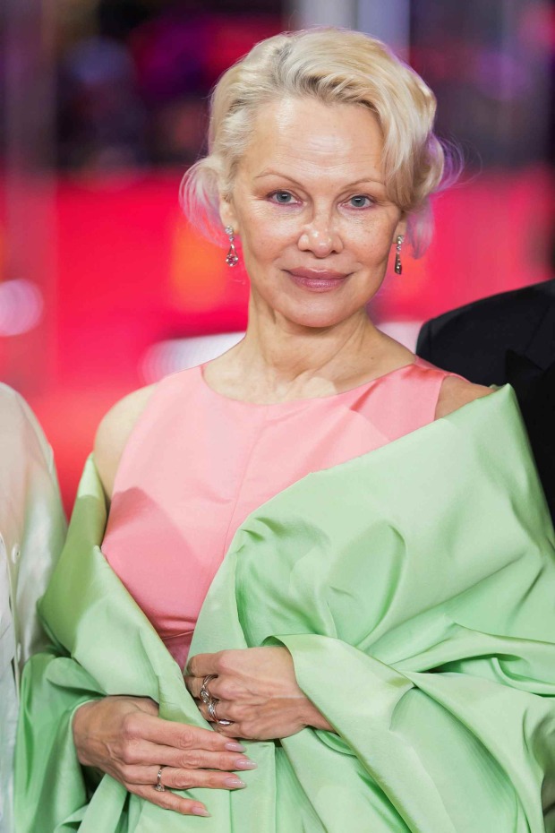 Pamela Anderson mit kurzer blonder Frisur und elegantem Pastell-Look bei einem aktuellen Event.