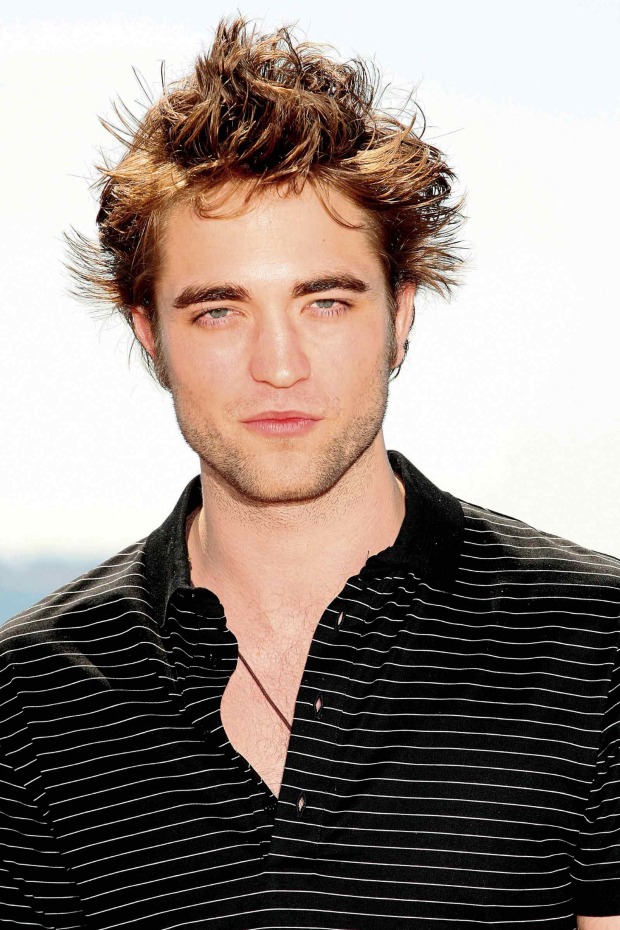 Junger Robert Pattinson mit wuscheligen Haaren und schwarzem Poloshirt bei einem Fototermin im Jahr 2009.