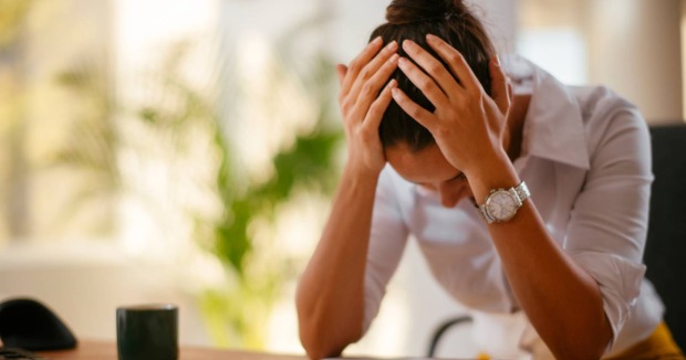 Frau über Tisch gebeugt, müde, energielos | Credit: Just Life/Shutterstock