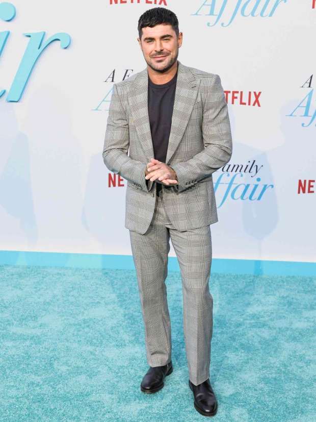Zac Efron im karierten grauen Anzug bei einer Filmpremiere.