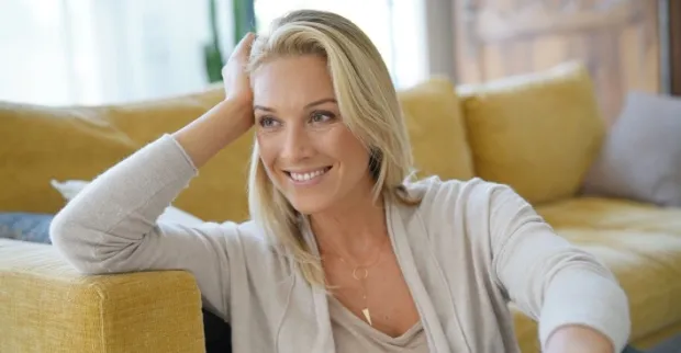Entspannte blonde Frau um die 40 | Credit: goodluz/Shutterstock