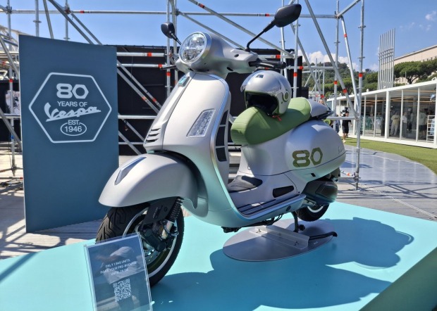 Jubiläums-Vespa in grau-grün steht im strahlenden Sonnenschein