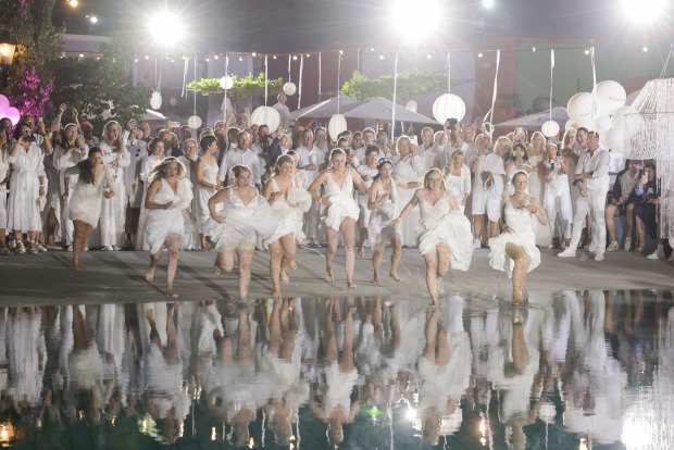 Zahlreiche Frauen in weißen Brautkleidern springen in das Wellenbecken im Rogner Bad Bllumauj