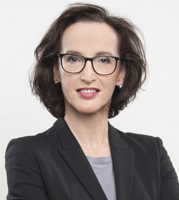 Frau mit dunklen Haaren, dunkler Brille und dunklem Blazer