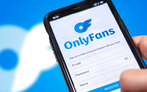 Hand mit Smartphone mit OnlyFans Logo