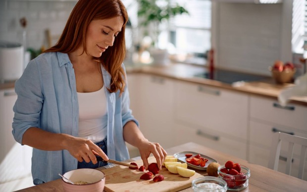 lächelnde Frau macht gesunden Snack in der Küche | Credit: Drazen Zigic/Shutterstock