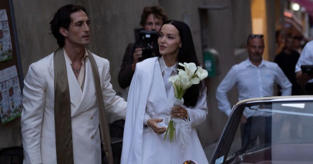 Dove Cameron und Damiano David bei ihrer Hochzeit in Montalcino in der Toskana neben einem weißen Oldtimer.