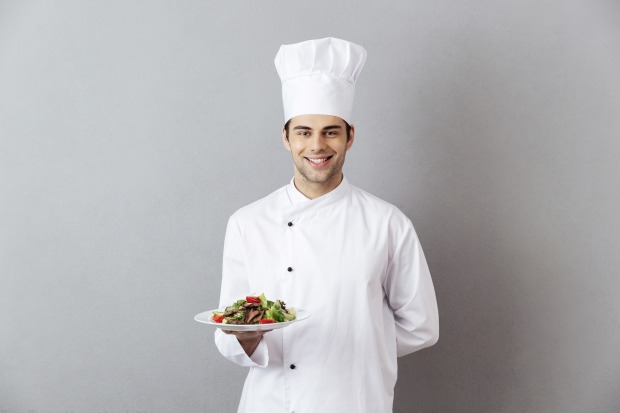 Koch in Uniform mit Essen in der Hand | Credit: Dean Drobot/Shutterstock