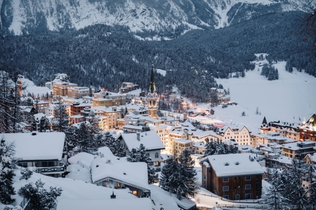 Der Ort mit Häusern und Hotels an einem bewaldeten Berghang.