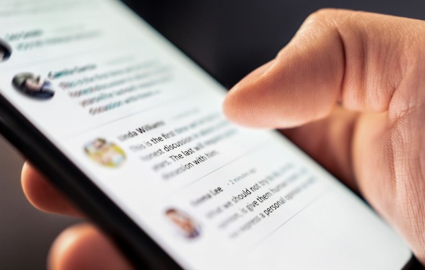 Jemand schaut sich etwas auf dem Handy an. Nur Finger sind zu sehen.