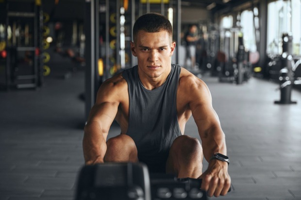 Ein junger Mann trainiert in einem Fitnesstudio.