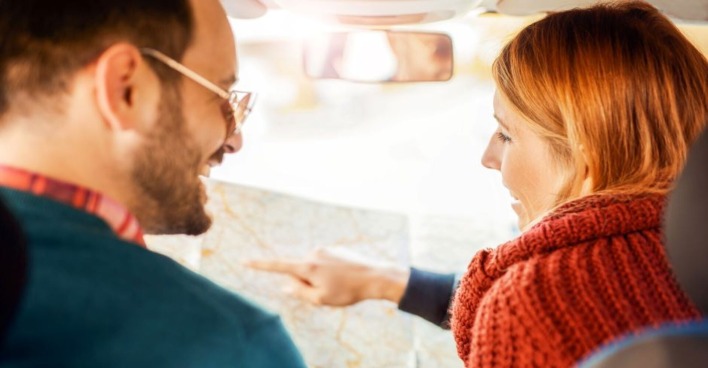 Paar sucht gemeinsam nach der Route auf der Straßenkarte | Credit: iStock.com/Bobex-73