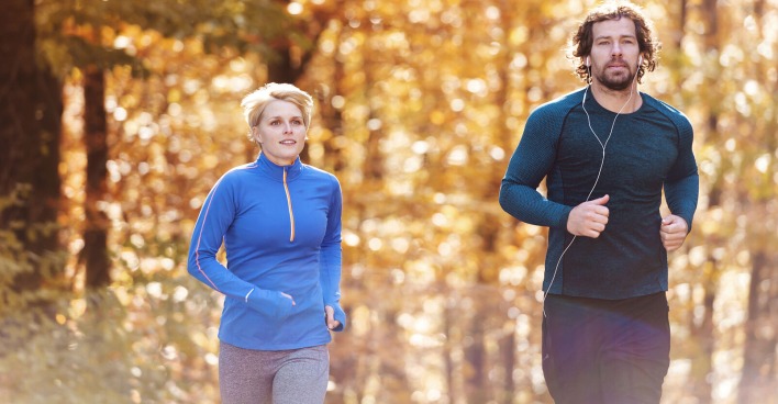 Paar joggt durch herbstlichen Wald