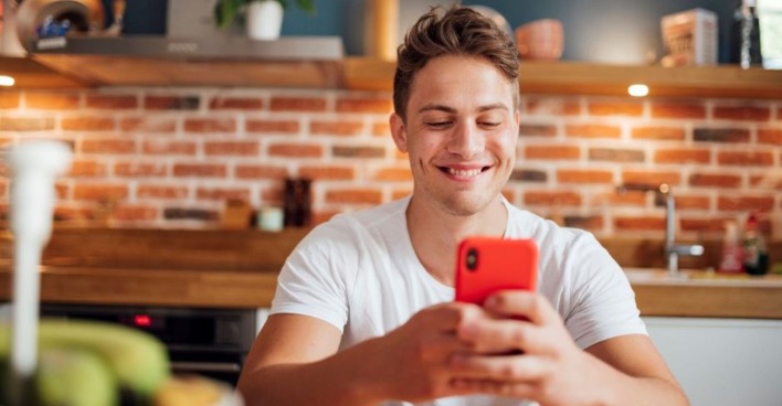 Junger Mann lacht über Smartphone-Witz | Credit: iStock.com/Pascal Skwara