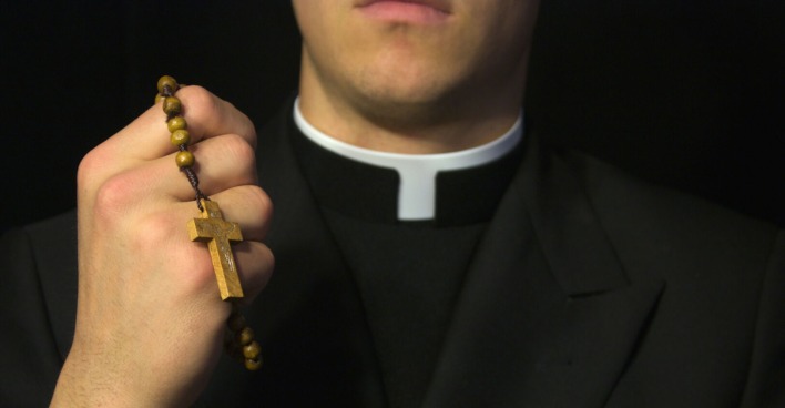 Priester mit Rosenkranz