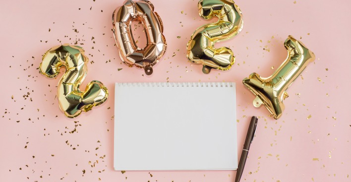 Tisch mit Silvesterdekoration sowie Block und Kugelschreiber