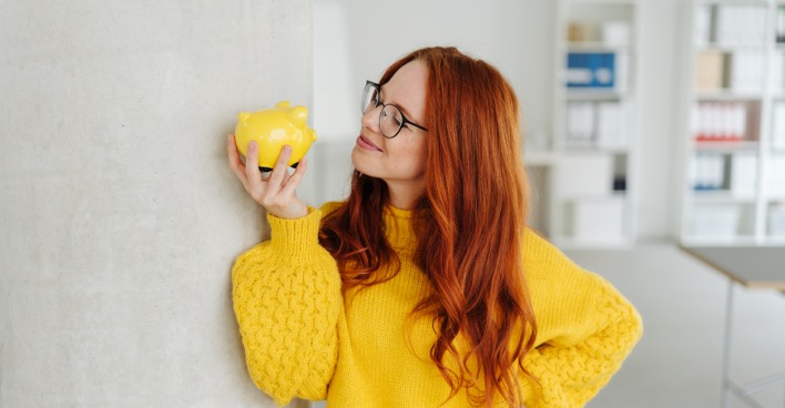 Junge Frau mit Sparschwein | Credit: iStock.com/stockfour
