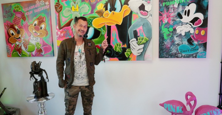 Pop-Art-Künstler Mario Stroitz in seiner Galerie vor bunten Bildern mit Comic-Motiven