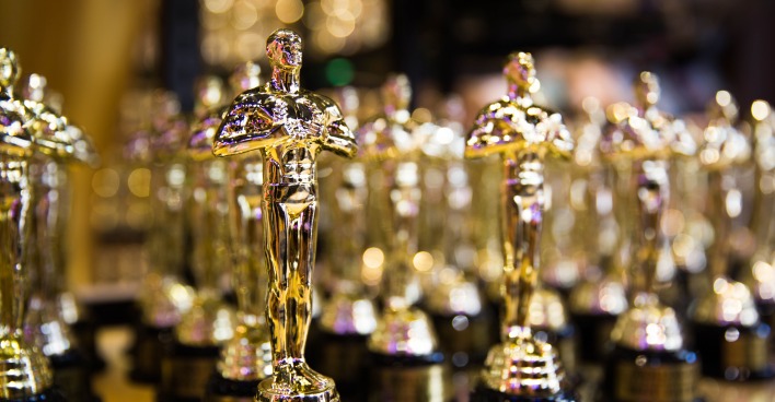 Mehrere Oscar-Statuetten auf einem Glastisch