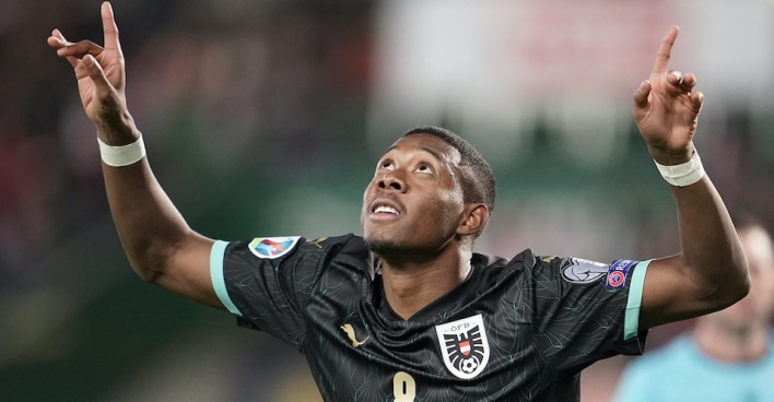 David Alaba im schwarzen Nationaldress blickt nach oben und jubelt mit beiden Händen in der Luft
