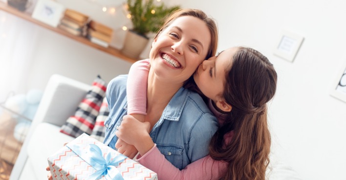 Junge Mutter freut sich über Geschenk von der Tochter