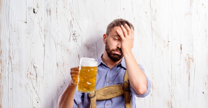 Betrunkener Mann hält Bierkrug
