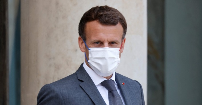 Ein Porträt-Foto von Präsident Macron: Er trägt einen grauen Anzug mit Krawatte und einen weißen Mund-Nasen-Schutz.