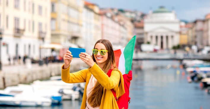 Junge Frau macht mit dem Smartphone ein Selfie in Triest
