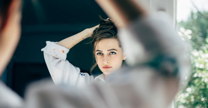 Frau begutachtet sich im Spiegel | Credit: iStock.com/Viktor_Gladkov