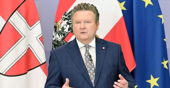 Bürgermeister Michael Ludwig steht vor einer Wien-, Österreich und EU-Flagge und erklärt die Maßnahmen.