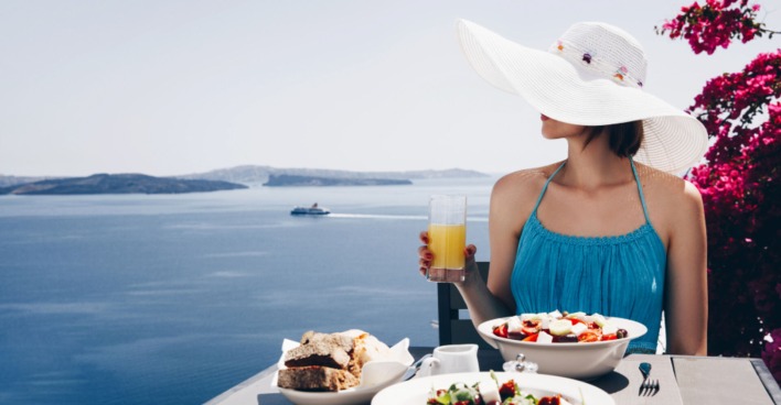 Frau beim Abendessen am Mittelmeer | Credit: iStock.com/katiafonti