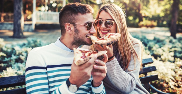 Pärchen beim Pizza-Essen im Park | Credit: iStock.com/Bobex-73