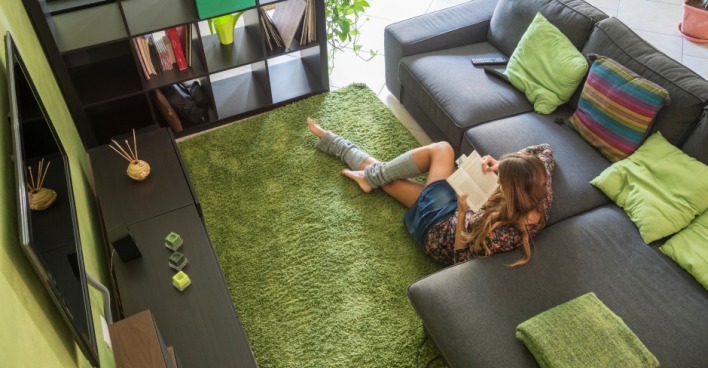 Frau liest im Wohnzimmer ein Buch | Credit: iStock.com/luana rigolli